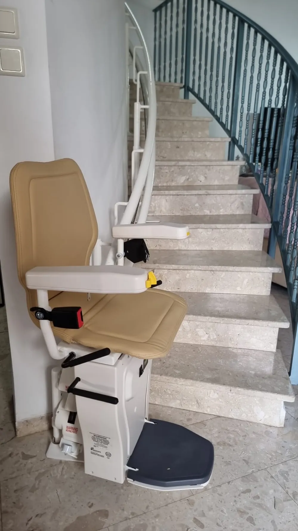 Sitzlift mit beigem Polster am Fuß einer Steintreppe – echtes Kundenobjekt
